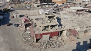 DEPREMİN VURDUĞU HATAY’DA 4 KATLI AĞIR HASARLI İŞ YERİNİN ÇATISINA