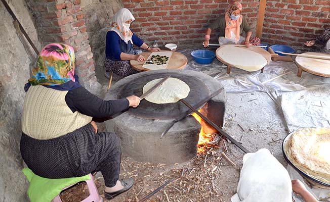 Osmaniye’nin sıcaklarının tüm zorluğuna rağmen saç ateşinin önünde yufka pişirmenin