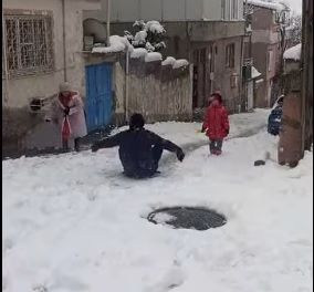 Kahramanmaraş’ın Onikişubat ilçesinde çocuklar, kar yağışını tepsi, naylon ve poşetlerle