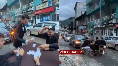 Bir grup genç, yola masa kurup iskambil oynayarak arkadaşlarının gelin